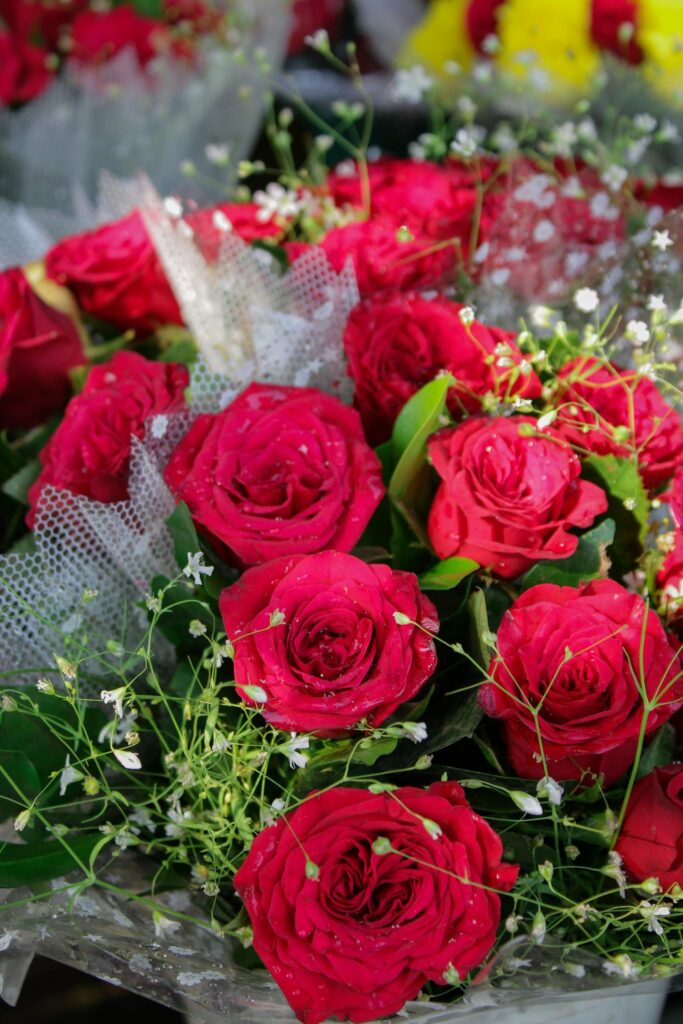 Close-up of a vibrant bouquet of red roses with delicate greenery, perfect for floral arrangements.