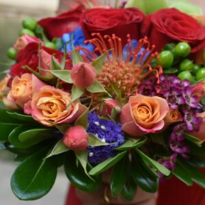 Photo by Lesli Whitecotton Colorful bouquet featuring roses, protea, and greenery, perfect for romantic occasions.